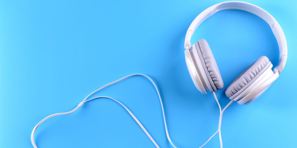 White corded headphones on a blue background