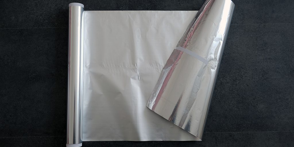 Roll of silver aluminum foil from the top down view with 18 inches unrolled and the end folded back